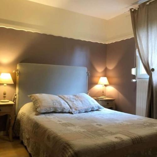a bedroom with a large bed with two lamps at Chambres d'hôtes Hébergement F.Mathieu in Saint-Maurice-sur-Moselle