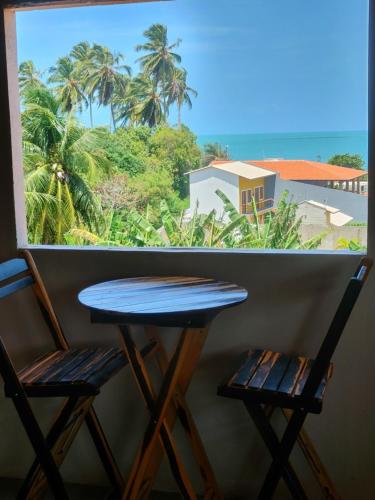 Pousada Viva Praia في باراكورو: طاولة وكرسيين أمام النافذة