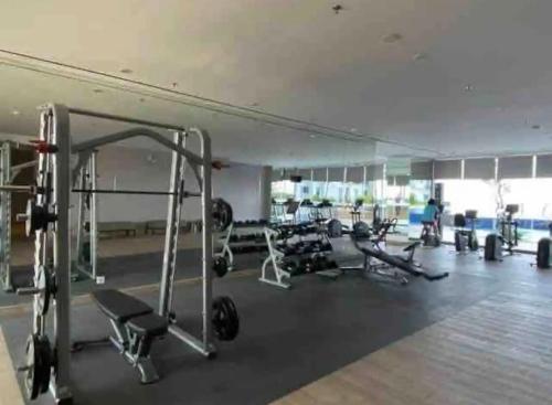 a gym with a lot of equipment in a room at 2 BR I ANDERSON I 18floor I above pakuwon mall I the biggest shopping center in Surabaya