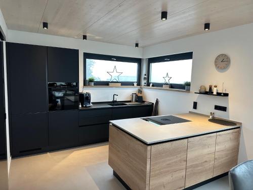Una cocina con gabinetes negros y encimera. en PanoramaChalet Winterberg, en Winterberg