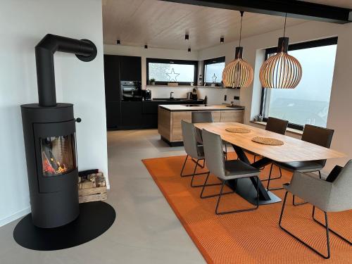cocina con chimenea y comedor con mesa en PanoramaChalet Winterberg, en Winterberg