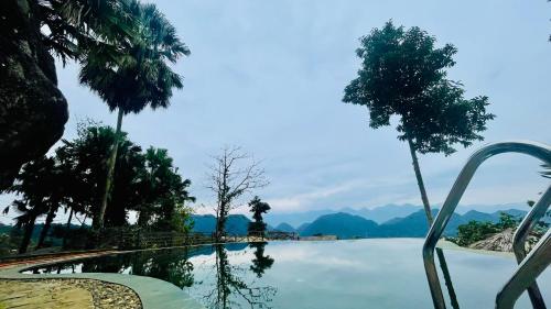 a swimming pool with trees and mountains in the background at Pu Luong Paradise in Hương Bá Thước