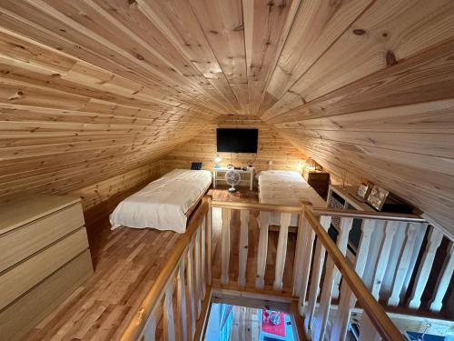 a room with two beds and a tv in a log kabine w obiekcie Luxdomki Kąty Rybackie w Kątach Rybackich