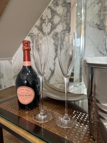 a bottle of wine and two wine glasses on a table at Old Town House by Ezestays in Margate