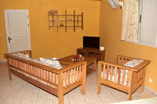 uma sala de estar com dois bancos e uma mesa em Villa Eugenie Ampasikely em Djamandjary