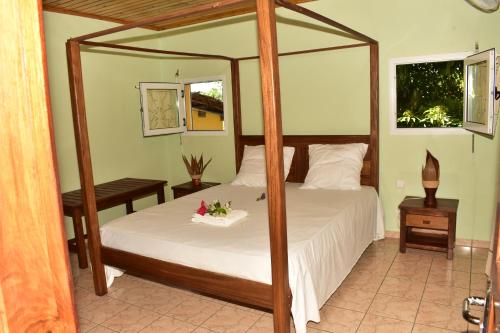um quarto com uma cama de dossel e uma colcha branca em Villa Eugenie Ampasikely em Djamandjary