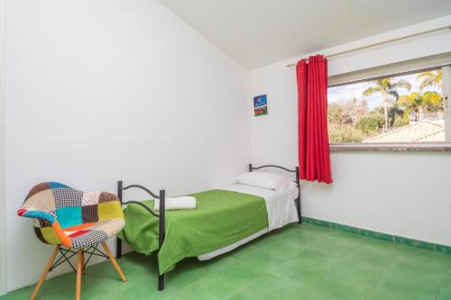 1 dormitorio con 1 cama, 1 silla y 1 ventana en Casa Geranio vista Etna en Calatabiano
