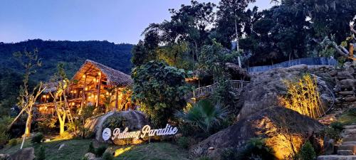 a house in the middle of a forest at night at Pu Luong Paradise in Hương Bá Thước