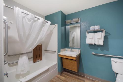 a bathroom with a shower and a sink and a toilet at WoodSpring Suites Macon North in Macon