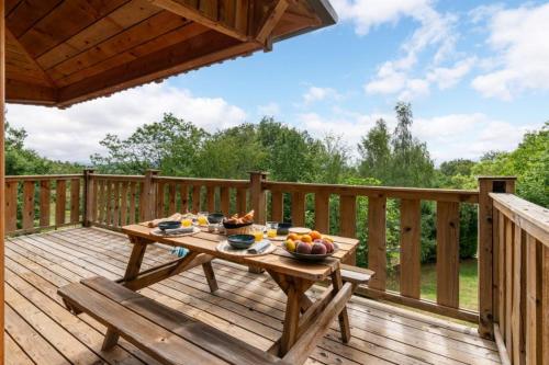 a wooden deck with a table with fruit on it at Camping LA SERRE in Aigues-Vives
