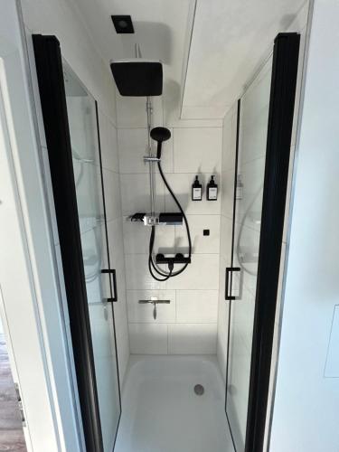 a shower with a glass door in a bathroom at Schönes Appartement mit Seeblick in Gummersbach