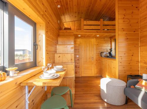 a wooden cabin with a table and chairs and a window at Les Tiny du Pré Mathy - Logements insolites avec Jacuzzi à Profondeville in Profondeville