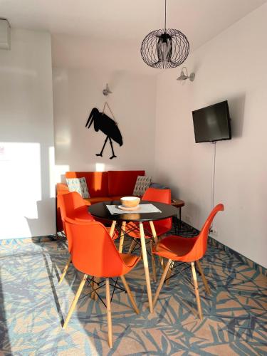 a dining room with a table and orange chairs at Baltic Sands in Hel