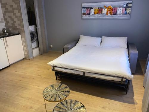 uma cama grande num quarto com duas mesas em STUDIO VIEILLE VILLE em Nice