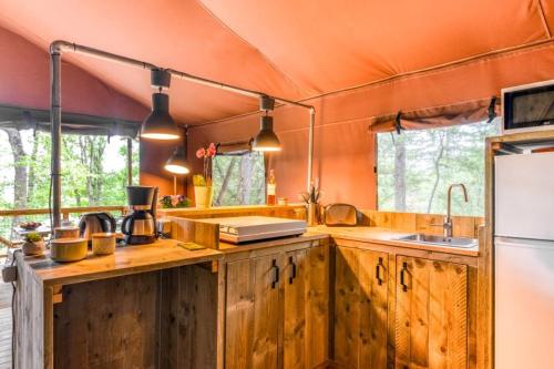 a kitchen with wooden cabinets and an orange ceiling at Camping LA SERRE in Aigues-Vives