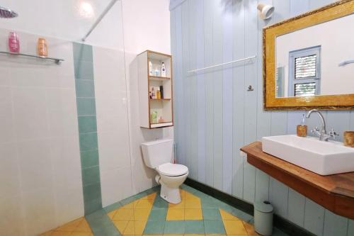 La salle de bains est pourvue d'un lavabo, de toilettes et d'un miroir. dans l'établissement VILLA La Perle PLAGE à PIED, PISCINE à Deshaies, à Deshaies