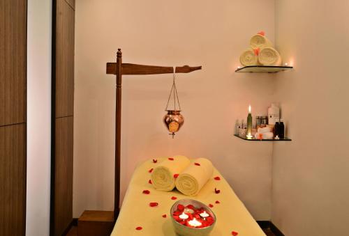 a room with a table with towels and a cross at Leisure Inn Grand Chanakya in Jaipur
