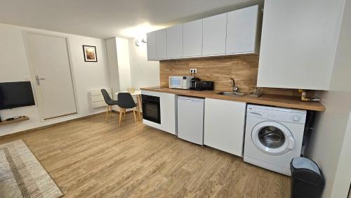 a kitchen with white cabinets and a washing machine at CosyNook - refait à neuf proche parc des expositions et aéroport CDG - Parking privé gratuit in Villepinte