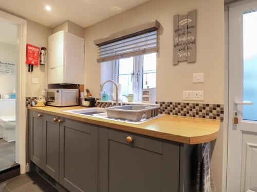 una cucina con un lavello e un piano di lavoro di Clematis Cottage a Belper