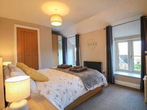 a bedroom with a bed and a large window at Clematis Cottage in Belper