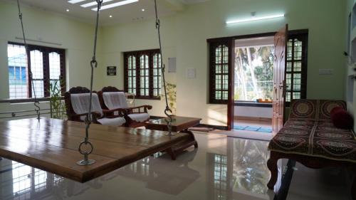 a living room with a wooden table and chairs at Honey Paradise Homestay in Trivandrum