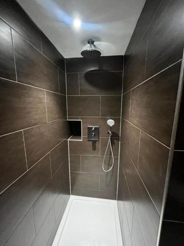 a bathroom with a shower with brown tiles at Tunnage Square Apartments Duke St by EPIC in Liverpool