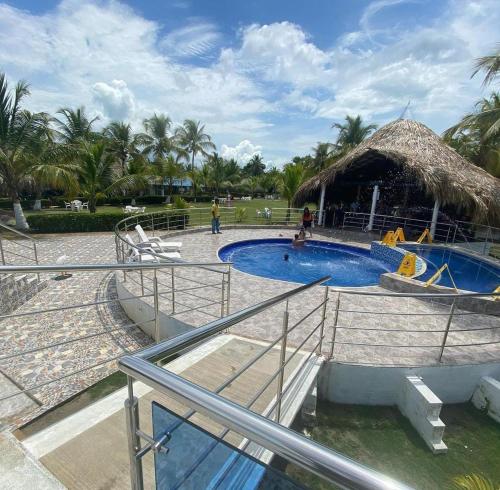 un complexe avec une piscine et une salle de bains de chaume dans l'établissement HOTEL CASA BLANCA, à Necoclí