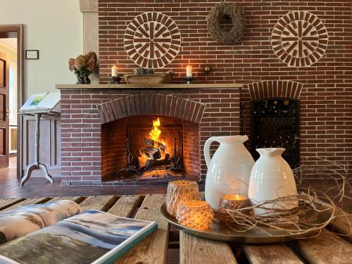 a living room with a fireplace and a table with two vases at Stimbekhof in Bispingen