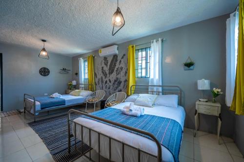 - une chambre avec 2 lits et des chaises dans l'établissement Rustic Raspuru, à St Mary