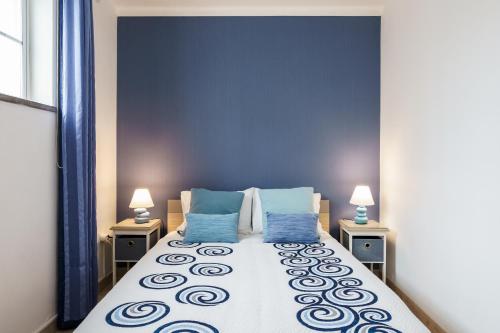 a bedroom with a large bed with blue walls at Apartment in a House in Tavira