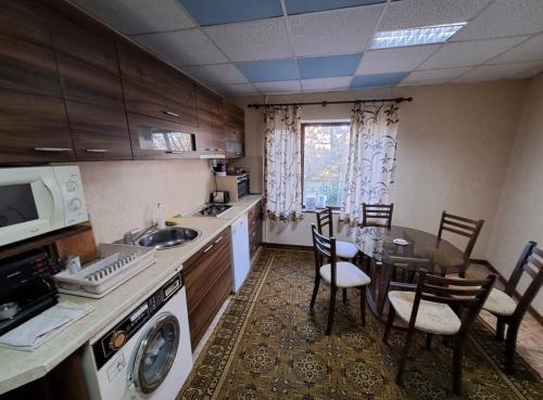 eine Küche mit einem Tisch, Stühlen und einer Mikrowelle in der Unterkunft Vila Dedo Liben in Vratsa