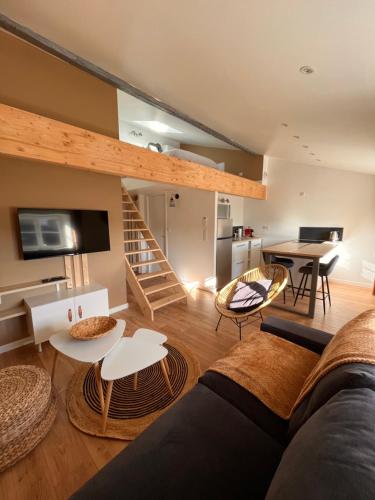 a living room with a couch and tables and a kitchen at Résidence de l'houmeau - proche gare in Angoulême