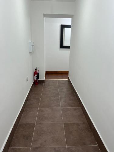 a hallway with white walls and a tile floor at Luxury 2 Bed Apartment at Seymour grove in Manchester