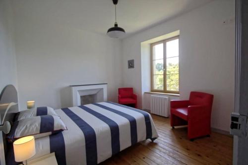 een slaapkamer met een bed en twee rode stoelen bij Villa : Les Embruns classé 4 étoiles in Bréhat