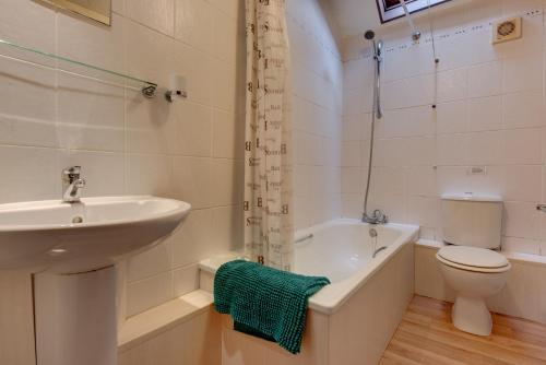 a bathroom with a sink and a toilet and a bath tub at Birds Farm in Colchester
