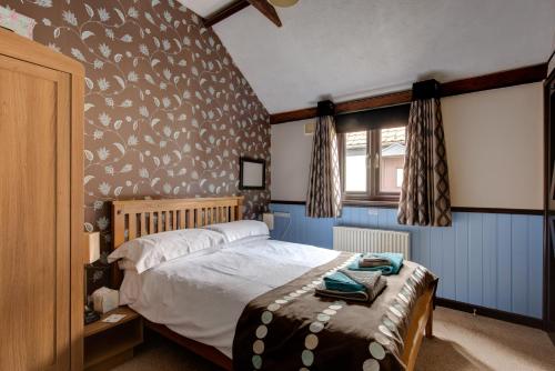 a bedroom with a bed with a bird patterned wall at Birds Farm in Colchester