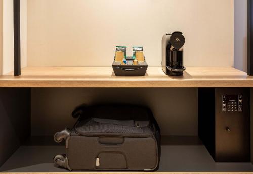 a shelf with a coffee maker and a box on it at B&B HOTEL Marne-la-Vallée Val d'Europe in Serris