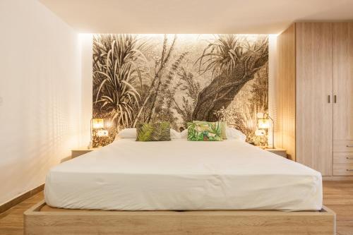 1 dormitorio con 1 cama blanca grande y un mural en la pared en Loft in Cabrils, en Cabrils