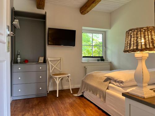a bedroom with a bed and a tv on the wall at Stimbekhof in Bispingen