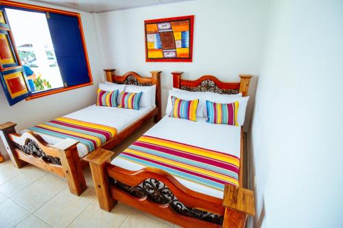 a bedroom with two twin beds and a window at Finca Nuevo Monarca in Pereira