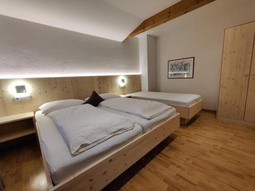 - une chambre avec 2 lits et des draps blancs dans l'établissement Room in Apartment - Residence Klementhof, à Fiumes