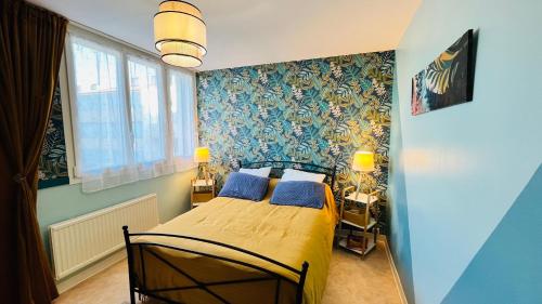 une chambre avec un lit aux murs bleus dans l'établissement Les Joncs, T2 lumière et mer, à Saint-Hilaire-de-Riez