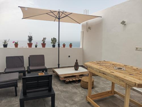 a patio with a table and chairs and an umbrella at Edy's STD04 in Imsouane