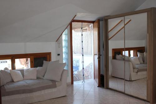 ein Wohnzimmer mit einem Sofa und einem Spiegel in der Unterkunft Villa Severino Ferrari Anzio in Anzio