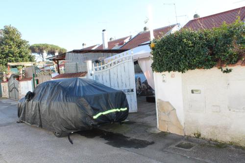 a car covered in a tarp parked next to a fence at Villa Severino Ferrari Anzio in Anzio