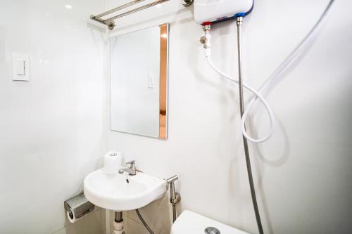 uma casa de banho branca com um lavatório e um espelho em Villa Soledad Garden Resort em San Pablo