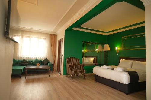 um quarto com uma cama e uma parede verde em Malabadi Hotel em Diarbaquir