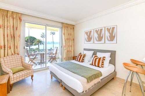 a bedroom with a bed and a balcony at Buckingham & Lloyds - Cannes in Cannes