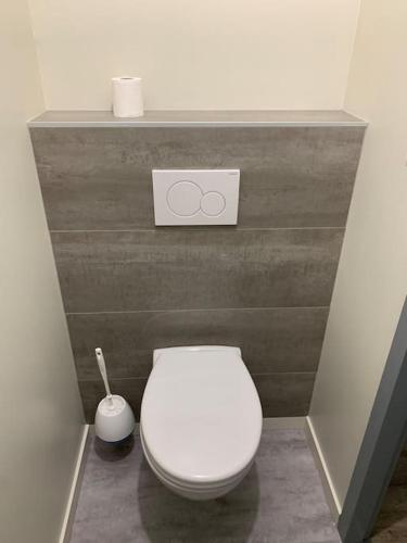 a bathroom with a white toilet in a wall at Appartement Torii - Maulévrier Cholet Puy du Fou in Maulévrier