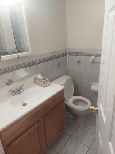 a bathroom with a white sink and a toilet at Deluxe Room A 12 minutes to Ewr in Newark